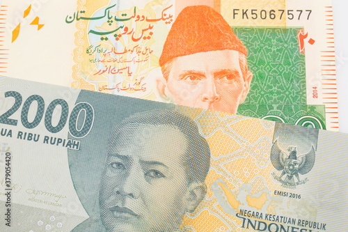 Wallpaper Mural A macro image of a grey two thousand Indonesian rupiah bank note paired up with a orange and green 20 rupee note from Pakistan.  Shot close up in macro. Torontodigital.ca
