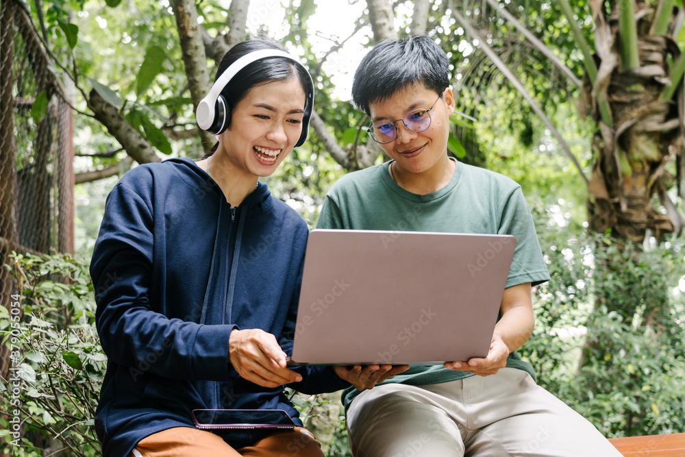 Happy friends looking at laptop outdoor at cafe. Happy friends looking at laptop outdoor at cafe.