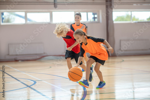 Kids in bright sportswear playing basketball in the gym © zinkevych