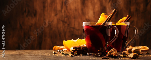 Canvas Print Hot mulled red wine cups with spices and fruits on wooden rustic table