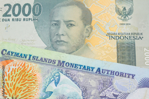 A macro image of a grey two thousand Indonesian rupiah bank note paired up with a colorful one dollar note from the Cayman Islands. Shot close up in macro.