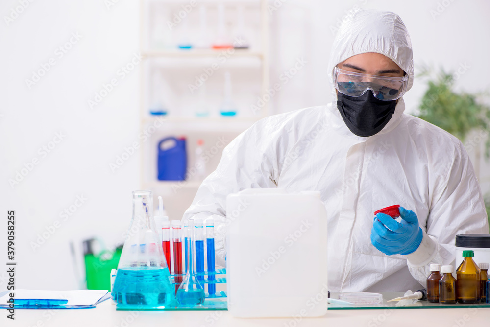 Young male chemist working in medicine lab Young male chemist working in medicine lab