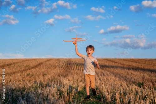 Happy child running with toy airplane on sky background happy family Concept. Childhood dream.