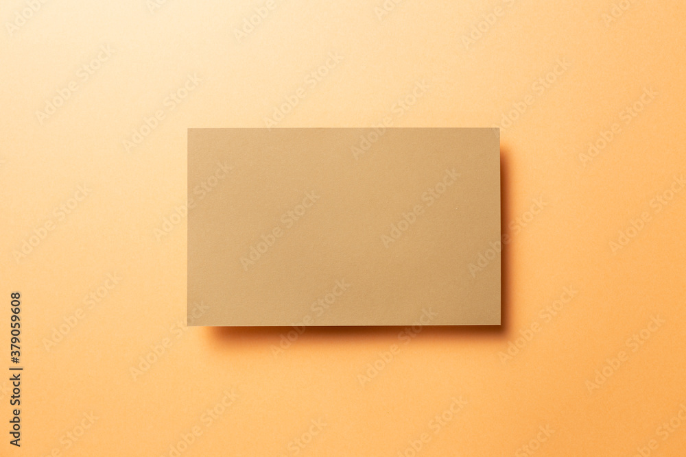 Kraft brown memo pad, empty paper on orange background. top view, copy space Kraft brown memo pad, empty paper on orange background. top view, copy space