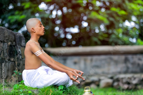 indian priest child doing yoga at park photo