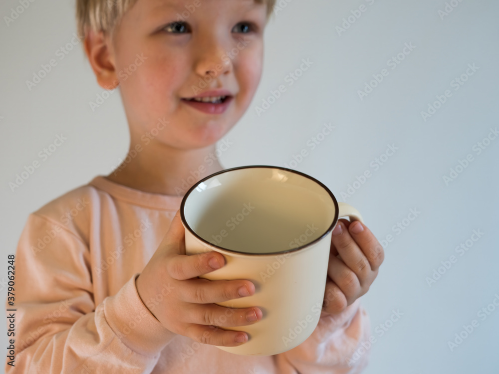 handsome blond boy with a fashionable haircut holds a light tea cup on a purple-blue background handsome blond boy with a fashionable haircut holds a light tea cup on a purple-blue background