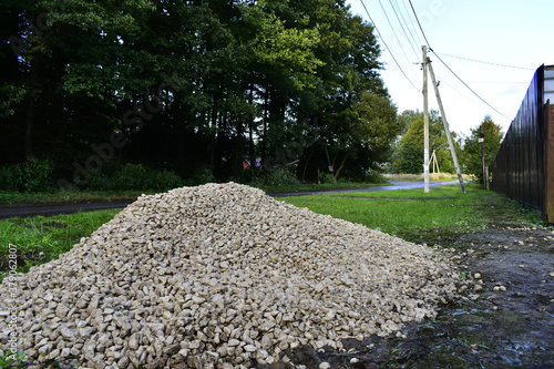 a pile of rubble on the grass by the road