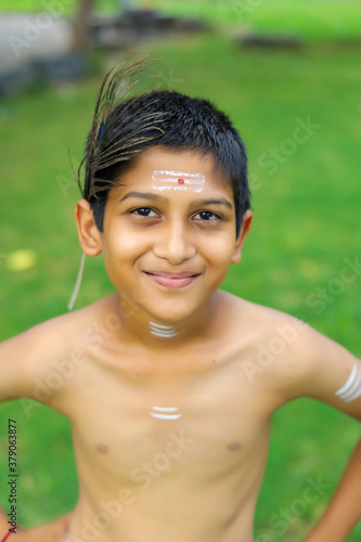 Little Indian boy posing as lord krishna