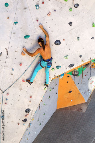 A man is climbing a climbing wall