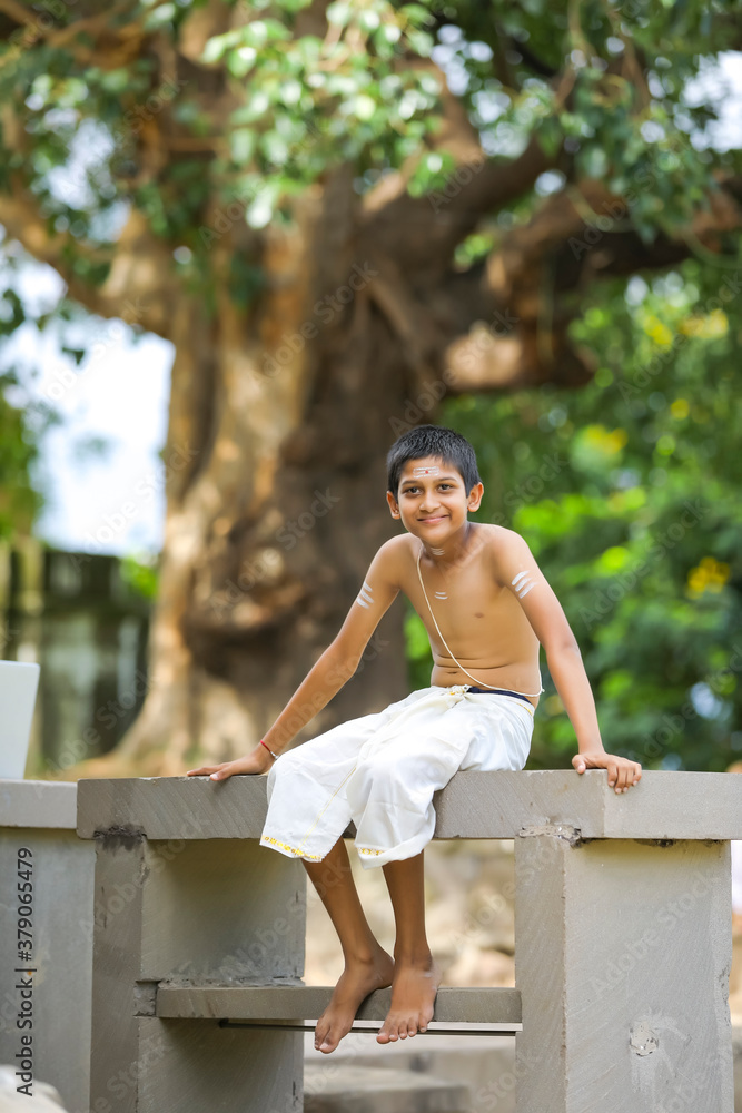 A indian priest child with holy water pot A indian priest child with holy water pot