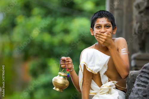 A indian priest child with holy water pot photo