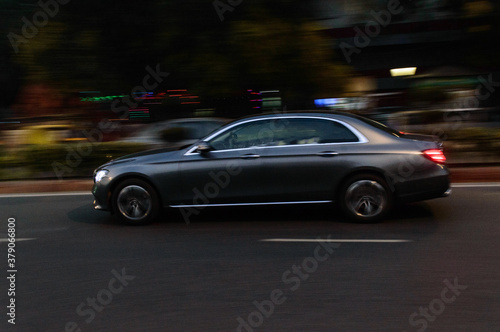 Panning technique of grey car which is going to market at night on the road © Shyam