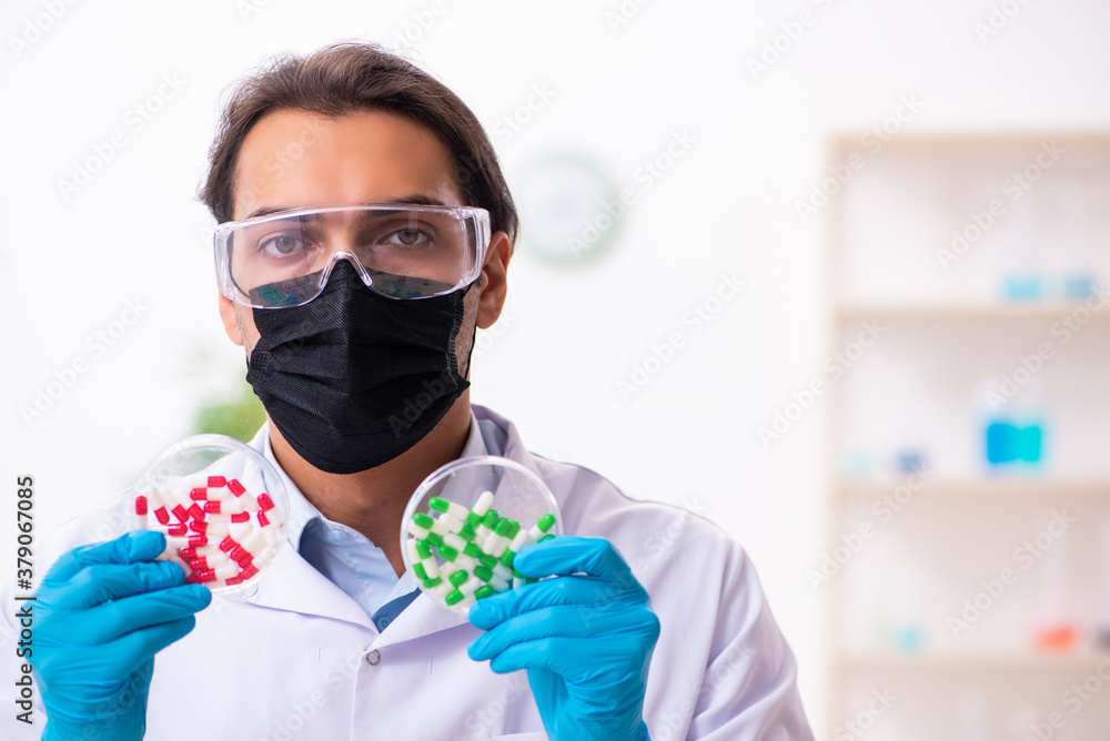 Young male chemist in drug synthesis concept Young male chemist in drug synthesis concept
