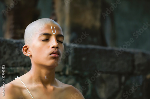 the indian priest child doing meditation photo