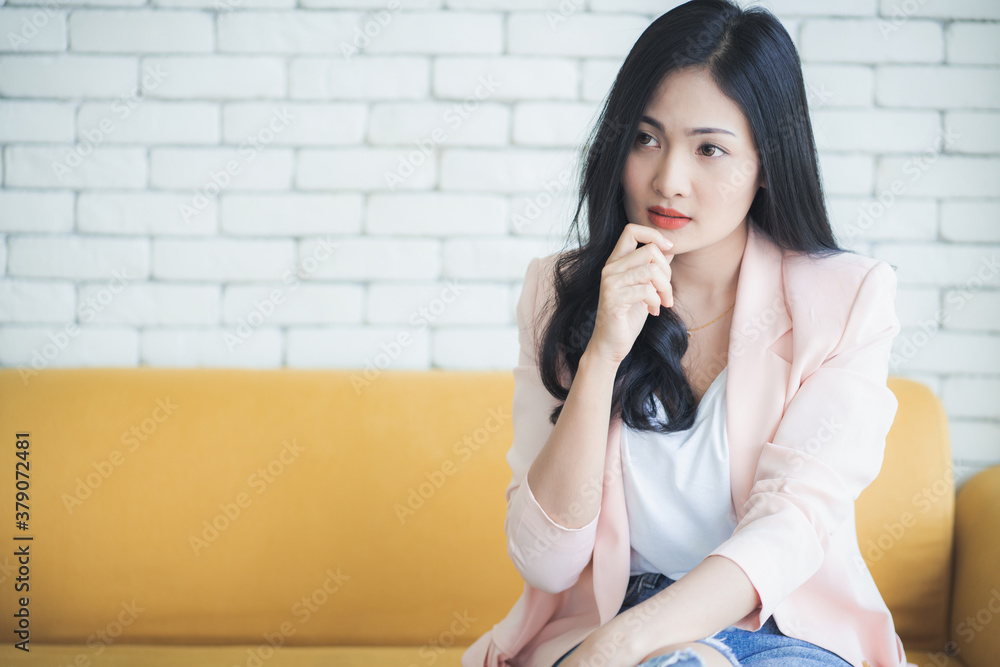 Asian woman thinking with finger near chin. Asian woman thinking with finger near chin.