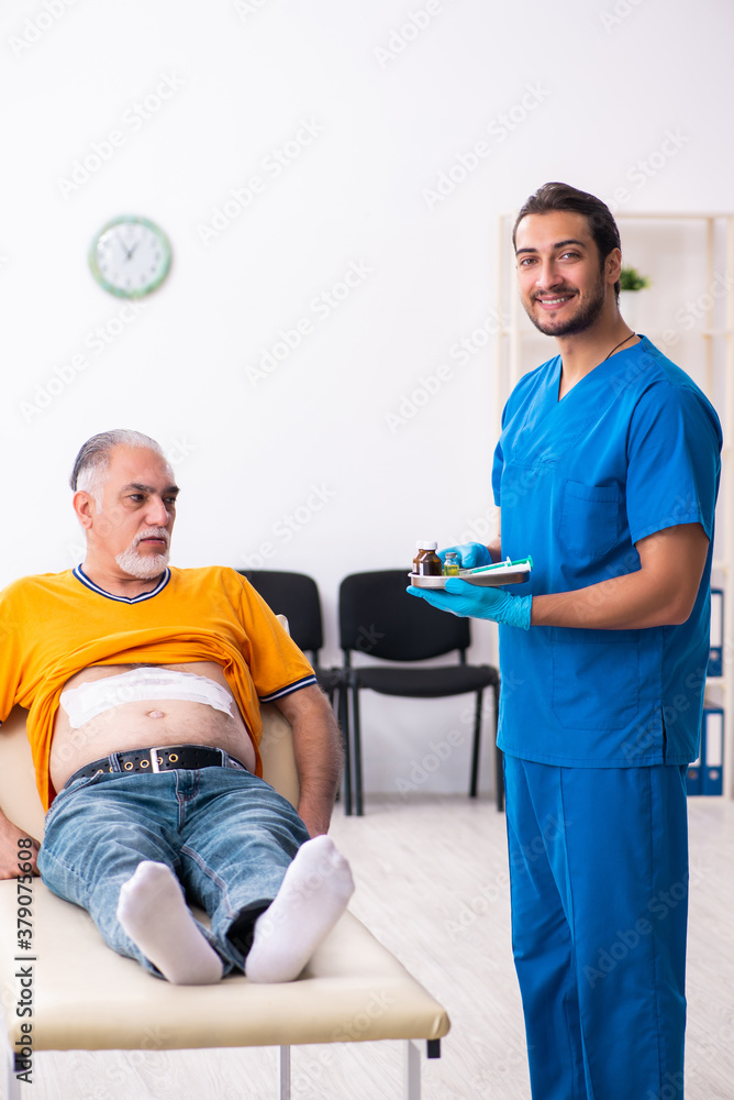 Old man visiting young male doctor Old man visiting young male doctor