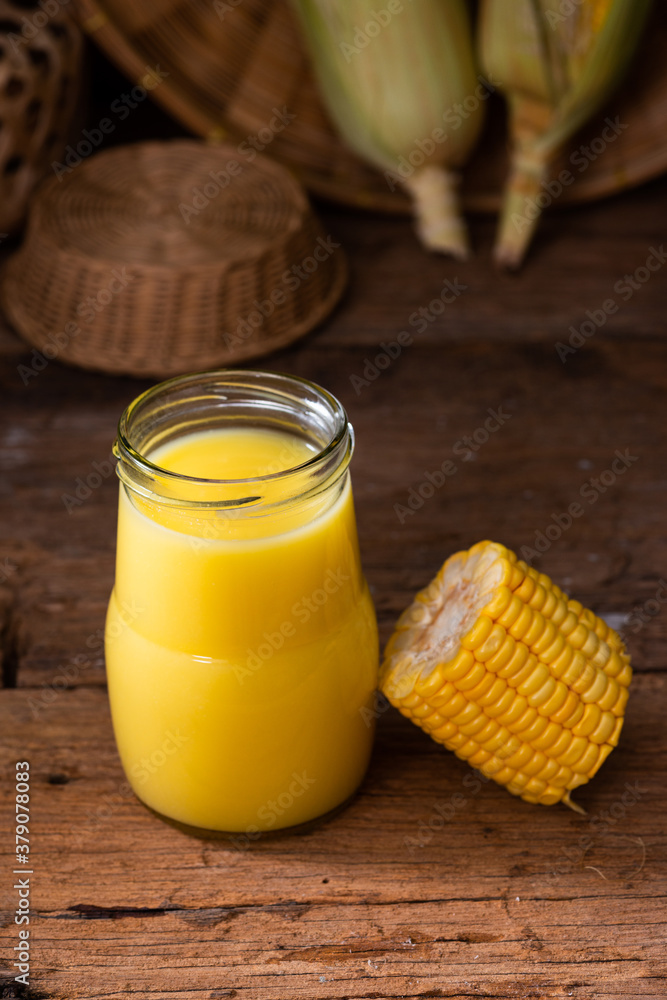 Fresh sweet corn juice (corn milk) and corn on wood background Fresh sweet corn juice (corn milk) and corn on wood background