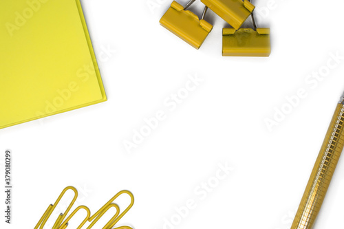 White background with yellow stationery on the sides. Paper clip clip pen. Top view with space for text