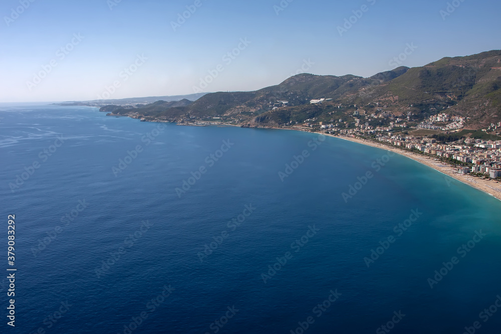 Blue sea and beautiful beach with mountains in the background