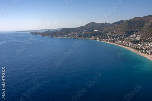 Blue sea and beautiful beach with mountains in the background © Kooper