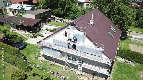 Workers to renovate a house. Aerial shot of thermal insulation of the facade of a family house.