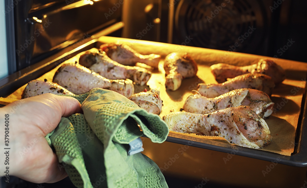 Fototapeta premium Baked chicken in the oven. Turkey legs on a baking sheet with spices baked in the oven. Snack on Thanksgiving Day.
