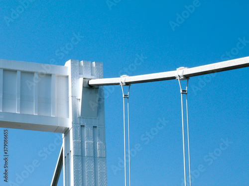 closeup detail of the white steel pillar and frame of the Elizbeth bridge in Budapest, Hungary. suspension ropes and cable bundle. clear blue sky. abstract low angle view. travel and tourism concept