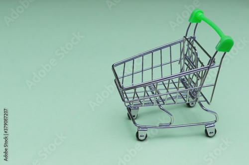 Empty shopping cart on soft blue background, buy and sell concept.