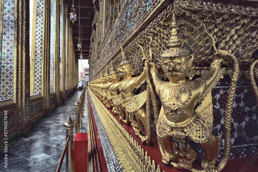 Obraz premium Closeup golden Garuda birds decorated on the wall of Buddhism temple in Thailand. Attractive place for tourism