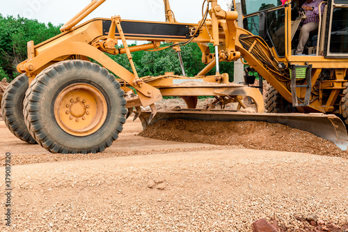 Grader Road Construction Grader industrial machine on construction of new roads. the blade of a motor grader in the process of leveling a sandy road foundation. Grader is working on road construction. photo