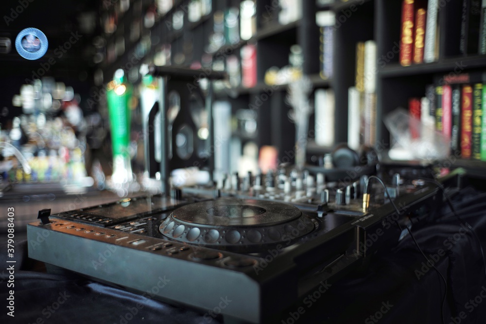 Closeup disc player control panel with blurred interior design of restaurant in background Closeup disc player control panel with blurred interior design of restaurant in background