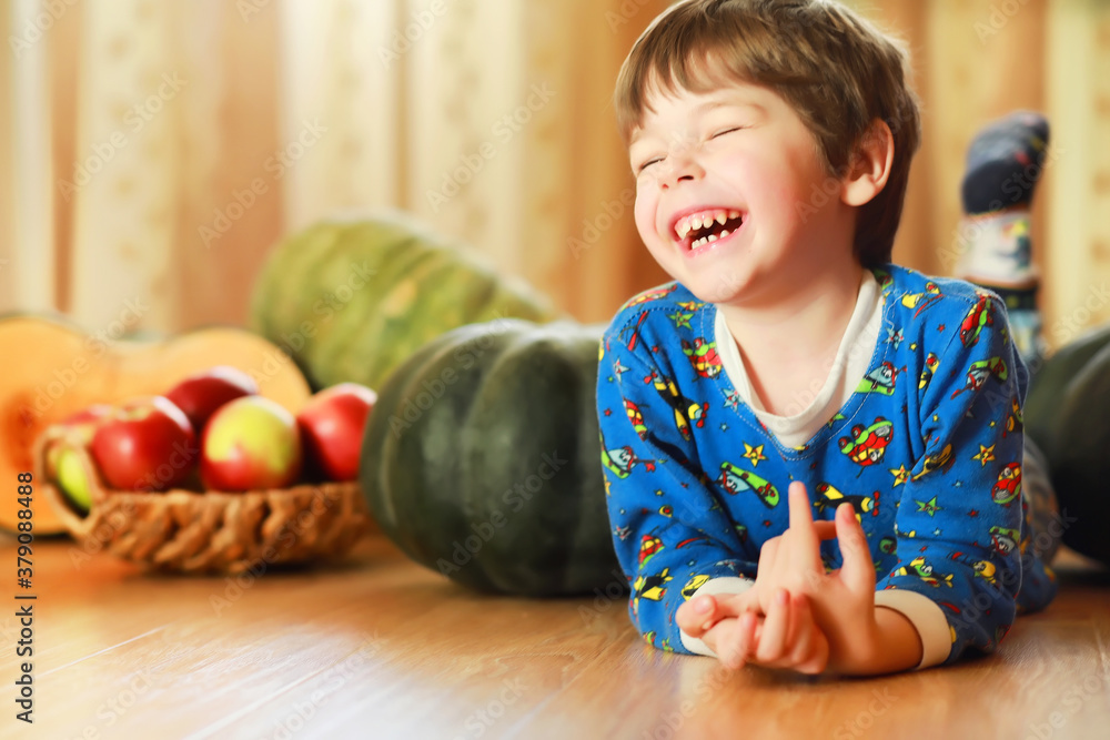 Fototapeta premium Little child choose a pumpkin at autumn. Child sitting on giant pumpkin. Pumpkin is traditional vegetable used on American holidays - Halloween and Thanksgiving Day.