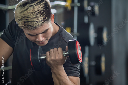 Strong sportsman lift up a dumbbell close up with copy space. © DG PhotoStock