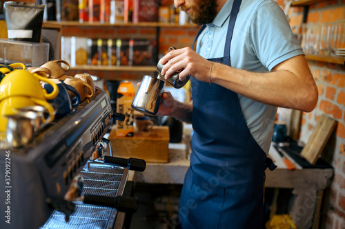 Male barista in apron prepares aroma coffee