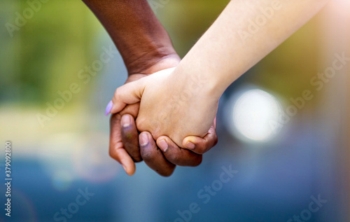 Interracial couple holding hands outdoors 