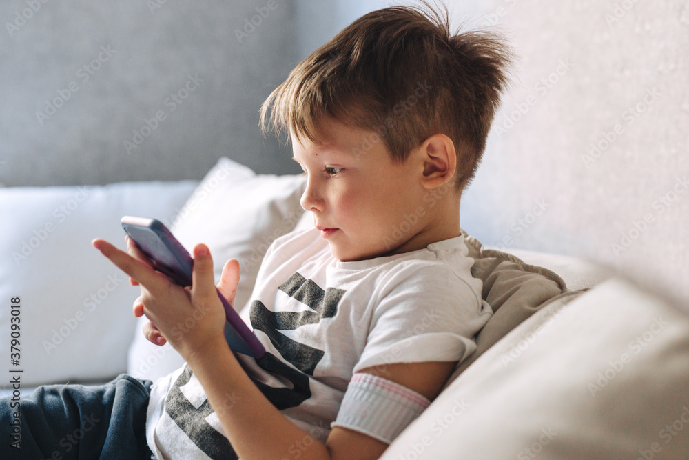 little boy sit on sofa and use phone at home little boy sit on sofa and use phone at home
