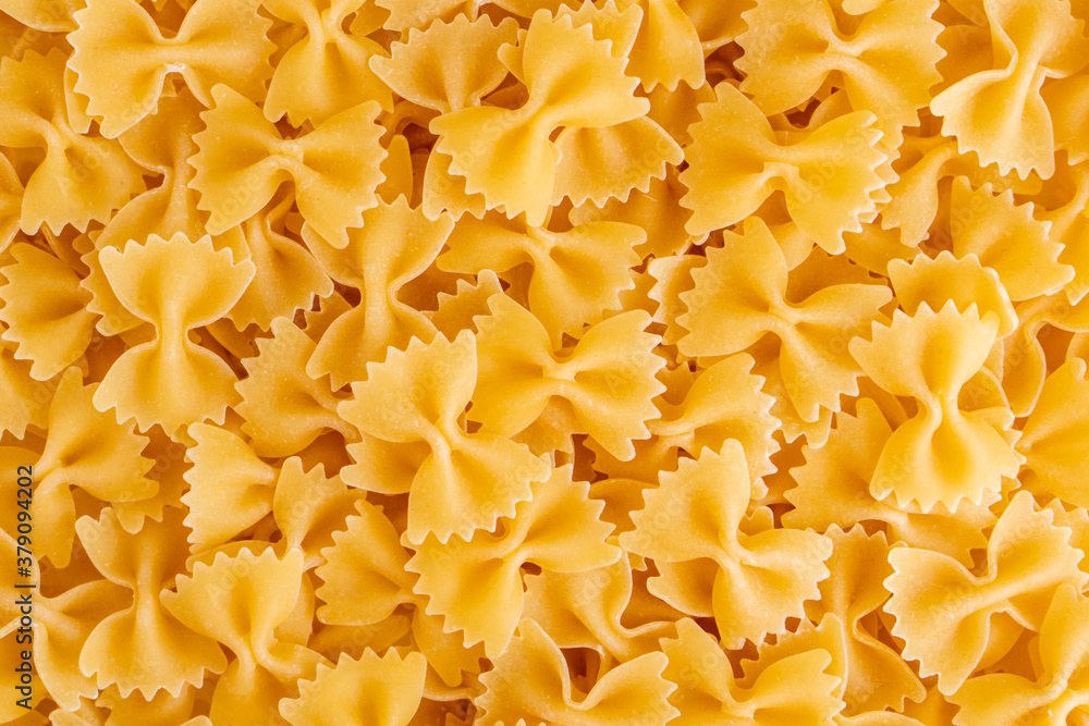 Raw dry uncooked Farfalle pasta spaghetti noodle on white bowl wooden background for basil tomato pesto sauce Homemade Italian food organic whole wheat vegan spaghetti for a healthy meal Raw dry uncooked Farfalle pasta spaghetti noodle on white bowl wooden background for basil tomato pesto sauce Homemade Italian food organic whole wheat vegan spaghetti for a healthy meal
