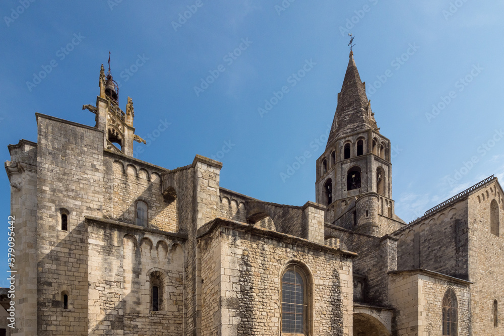 Bell towers of the church of Saint Andéol against a backdrop of blue sky, France