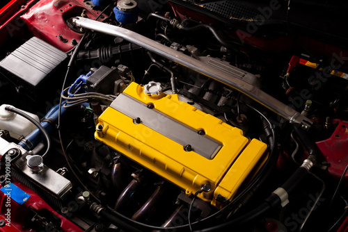 Car maintenance series: Closeup of yellow engine in red car