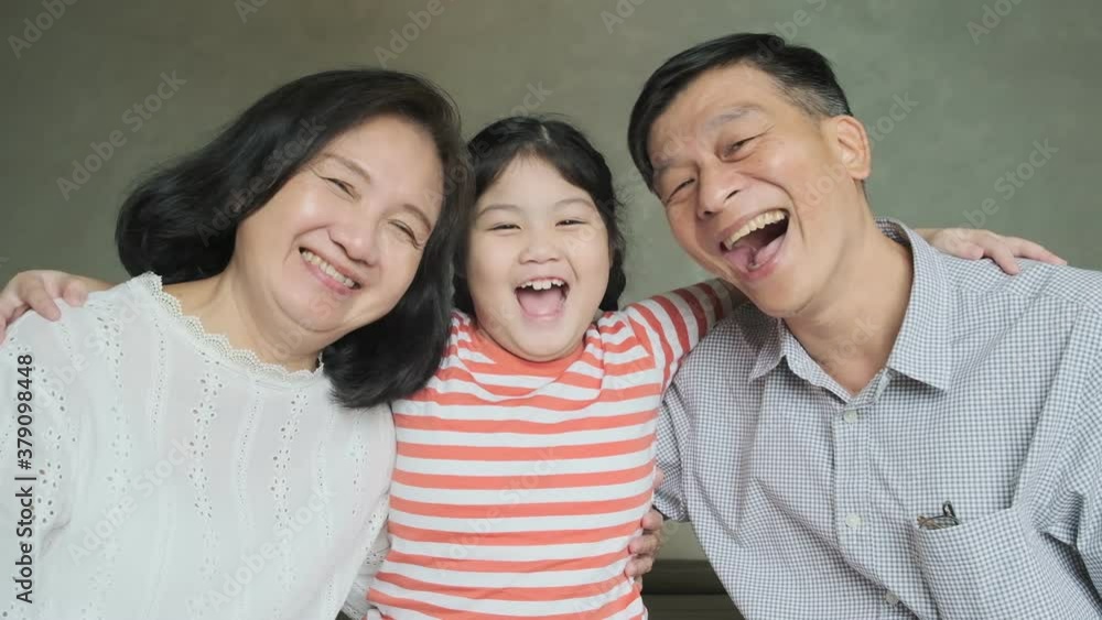 Happiness asian Grandmother and grandfather playing on bed together laugh smile with their granddaughter. Happiness asian Grandmother and grandfather playing on bed together laugh smile with their granddaughter.