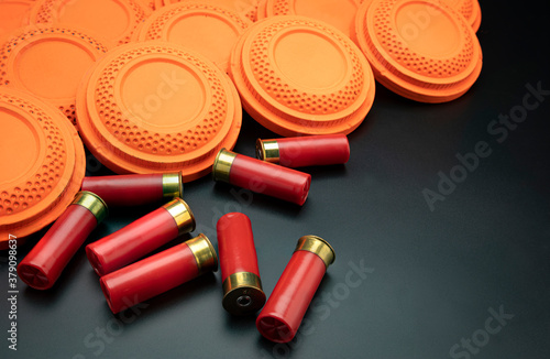 Fotografie, Obraz Clay disc flying targets and shotgun bullets on black background ,Clay Pigeon ta