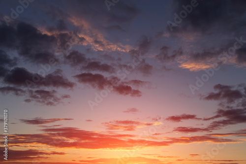Beautiful sunrise, sunset orange yellow pink blue sky with clouds and sunlight background texture