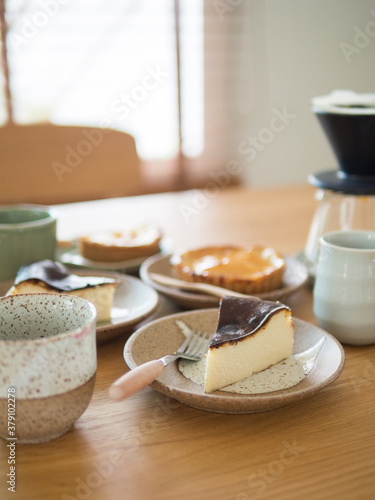 Selective focus at first dish of cake, collection of sweet bakery on wood table in cafe.