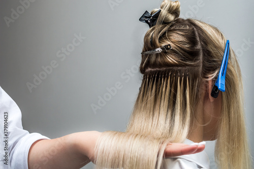 Hair extensions to a client close up in a beauty salon