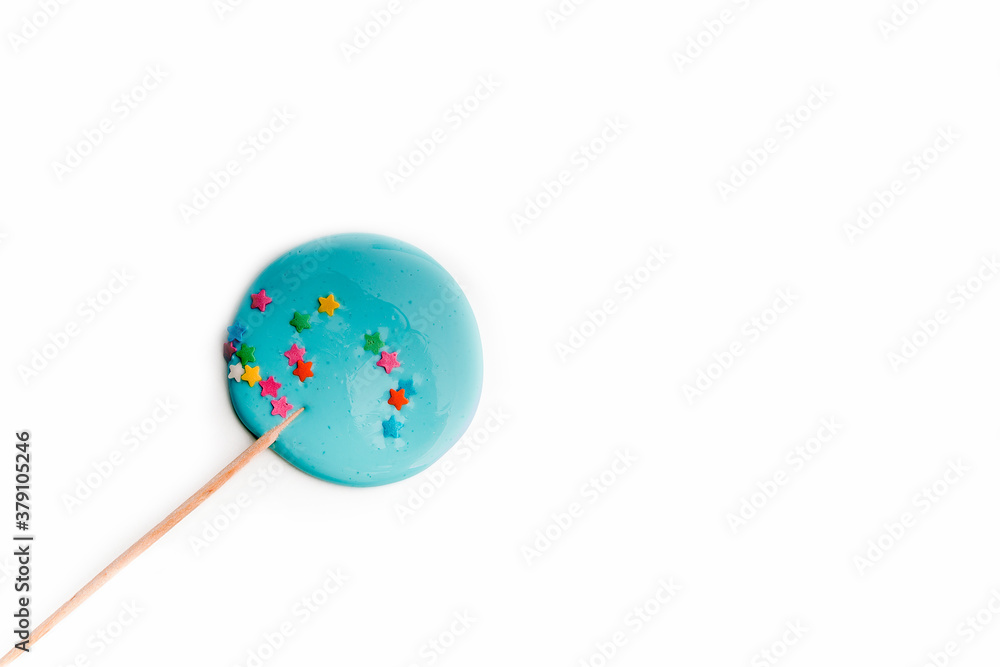 Hand made blue lollipop on wooden stick on white background. The concept of sweets for the holidays, birthday. Candy bar. Flat lay. Copy space for text. Hand made blue lollipop on wooden stick on white background. The concept of sweets for the holidays, birthday. Candy bar. Flat lay. Copy space for text.