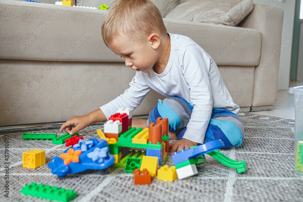 Child playing with toy blocks sitting on floor Child playing with toy blocks sitting on floor