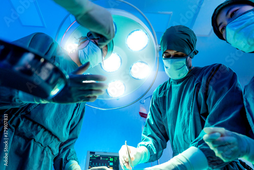 Group of asian doctor and nurse surgeons in hospital operating theater. Medical team performing surgery in operation room.Medical team doing critical operation.health and wellness concept