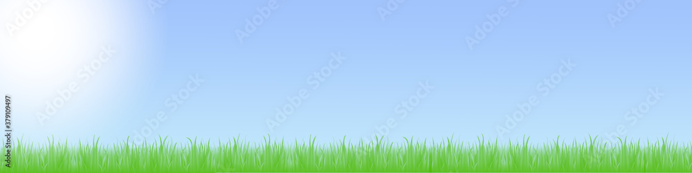 Fototapeta premium Landschaft mit grüner Wiese und blauem Himmel mit Wolken