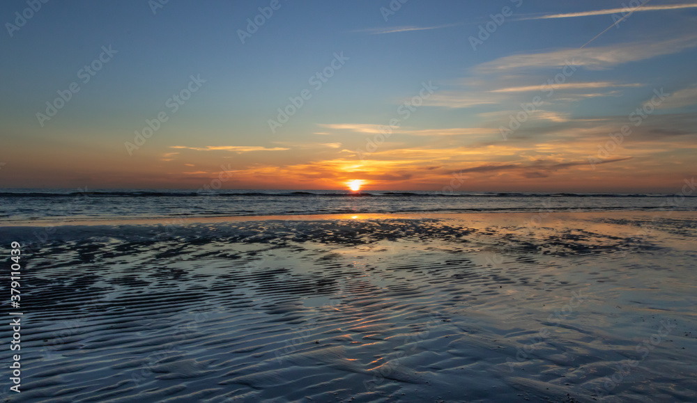 Zachód słońca na plaży w Egmond aan Zee, Holandia Północna.