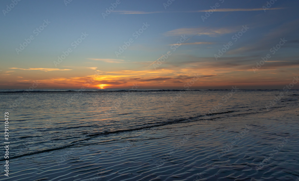 Zachód słońca na plaży w Egmond aan Zee, Holandia Północna.
